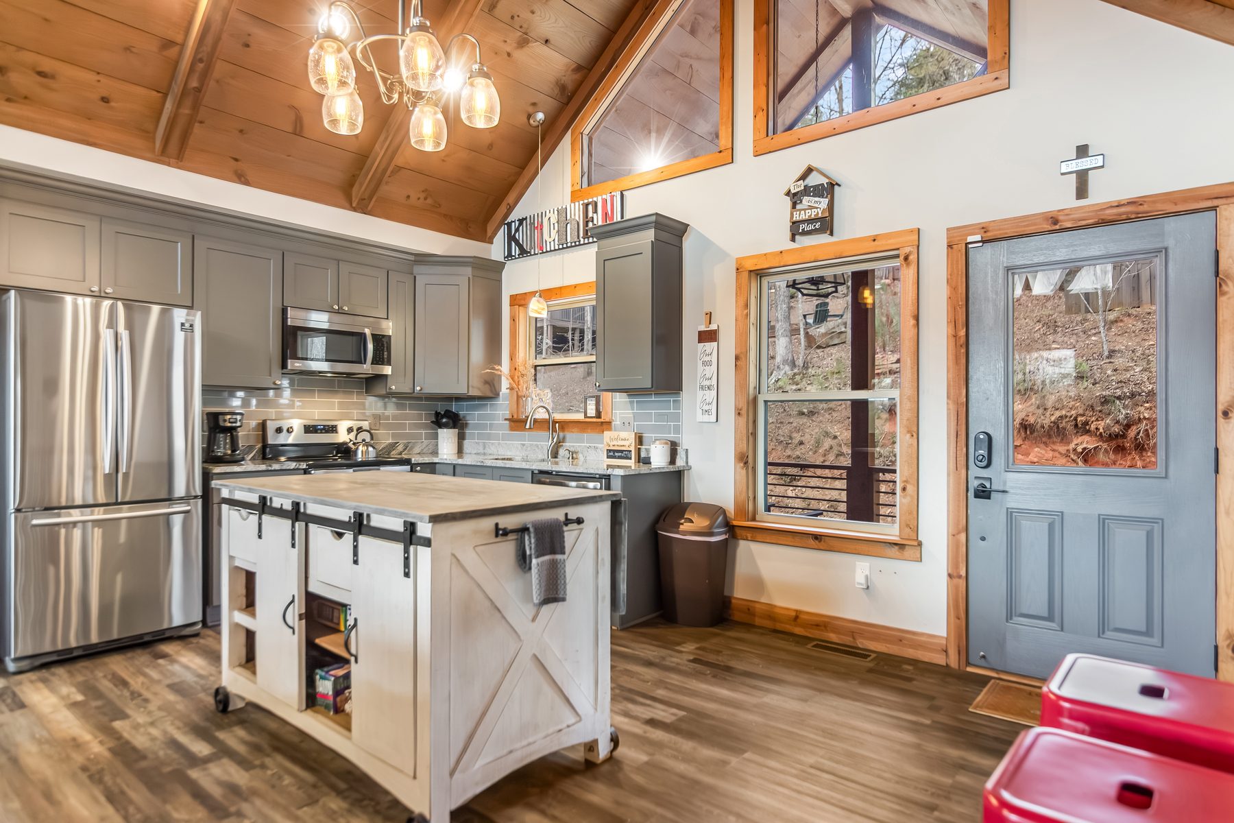 Kitchen with stainless steel appliances and Kitchen sign, woodland view through the window