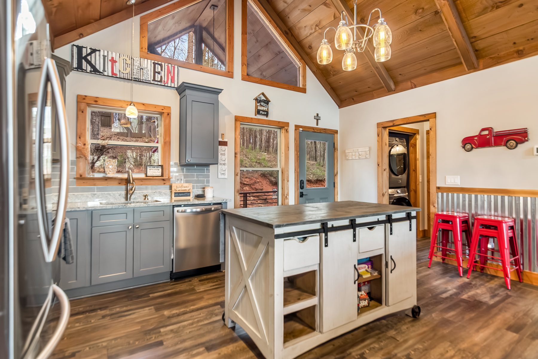 Kitchen looking toward the front door, with red bar stools and Kitchen sign