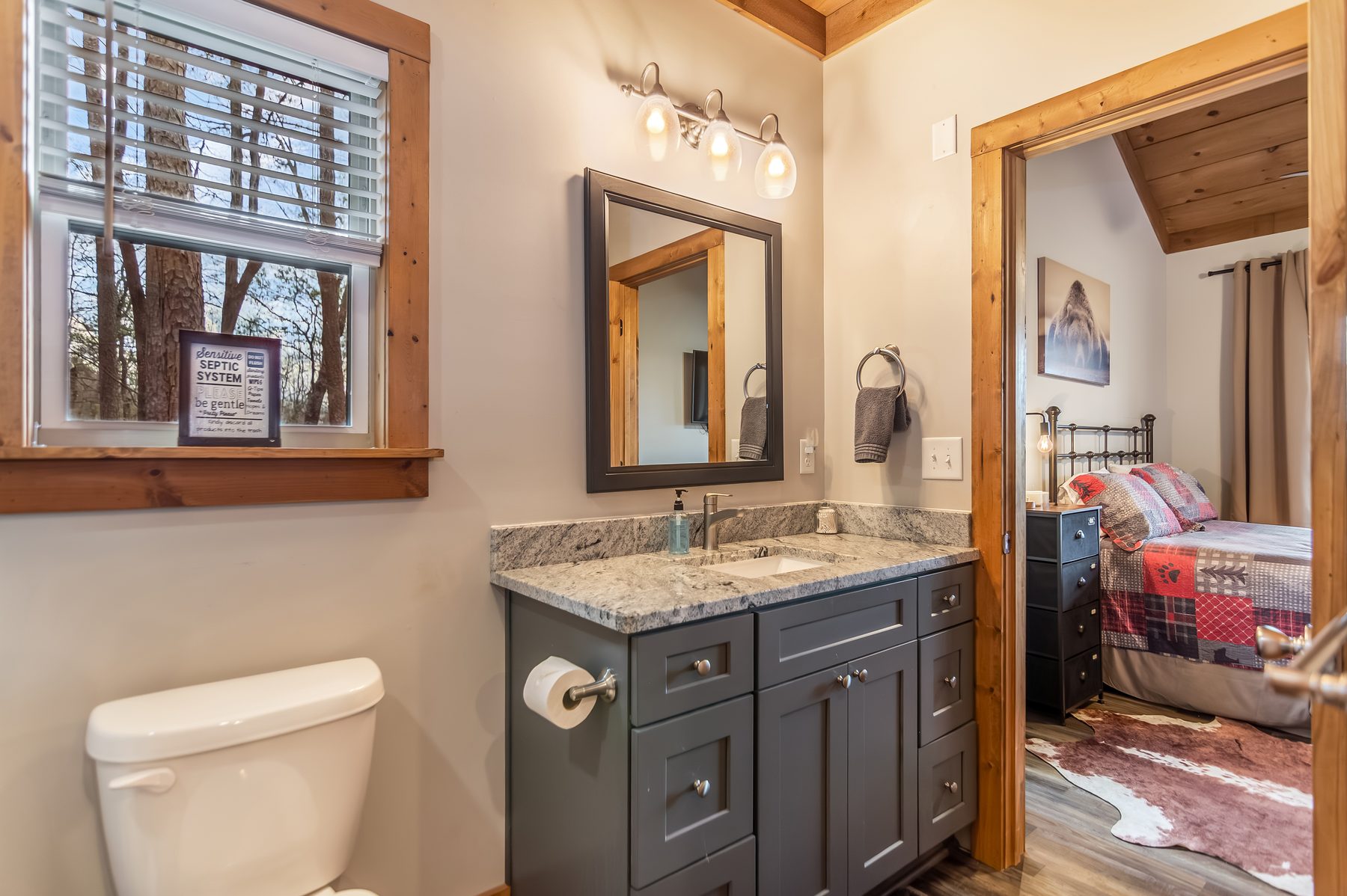 Bathroom vanity with granite top and view through to a bedroom