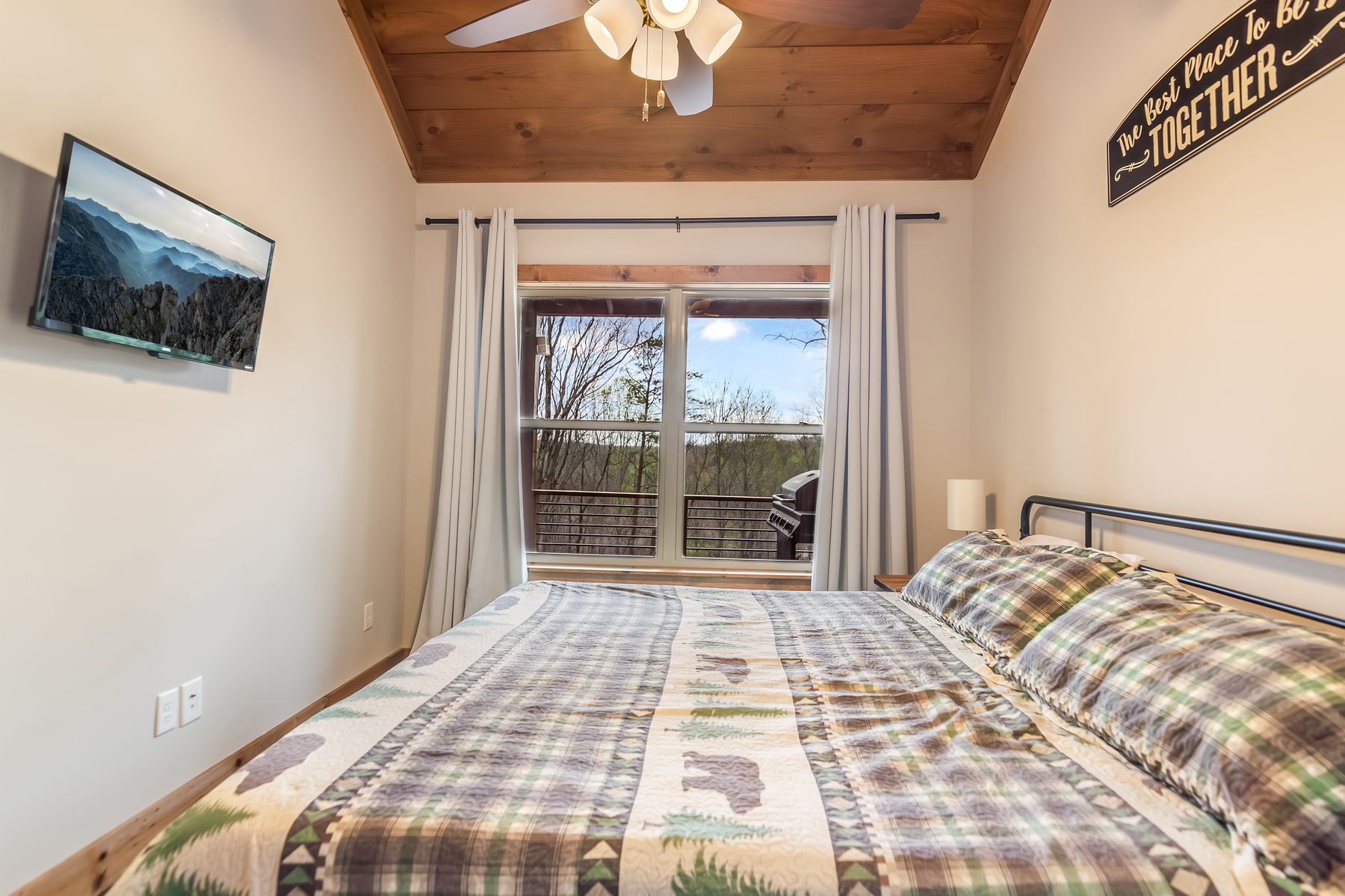Bedroom view from the bed toward the windows looking onto the deck and woods