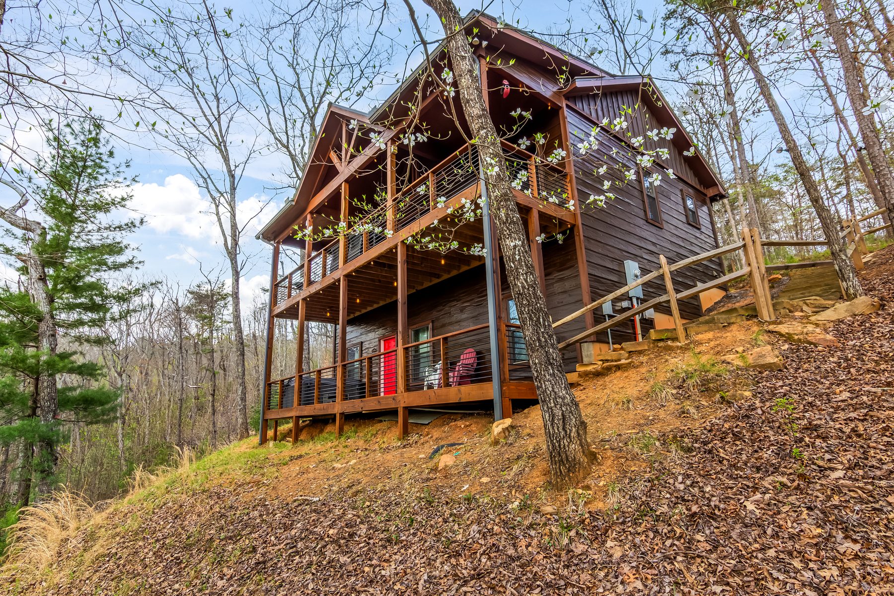 Cabin exterior side view from below the hillside, showing two levels of decking